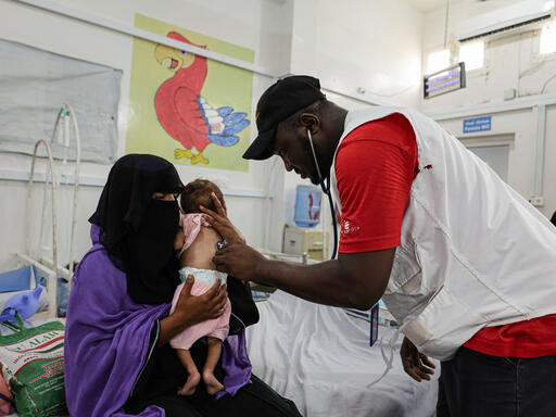 Un employé de MSF examine un bébé