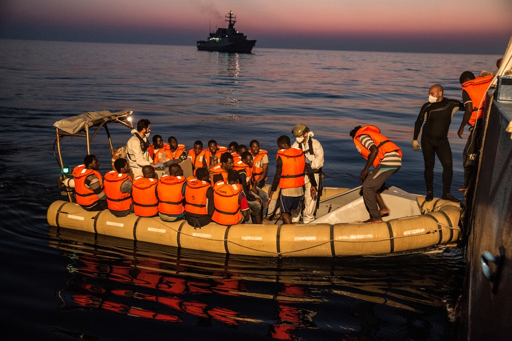 De mensen die gered werden van een gekapseisde boot worden overgebracht op de boot die hen aan wal zal brengen. © Anna Surinyach/MSF