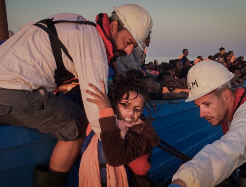 Een meisje wordt uit een boot met 350 mensen gehaald en op de Dignity l gezet © Nicolas Castellano.