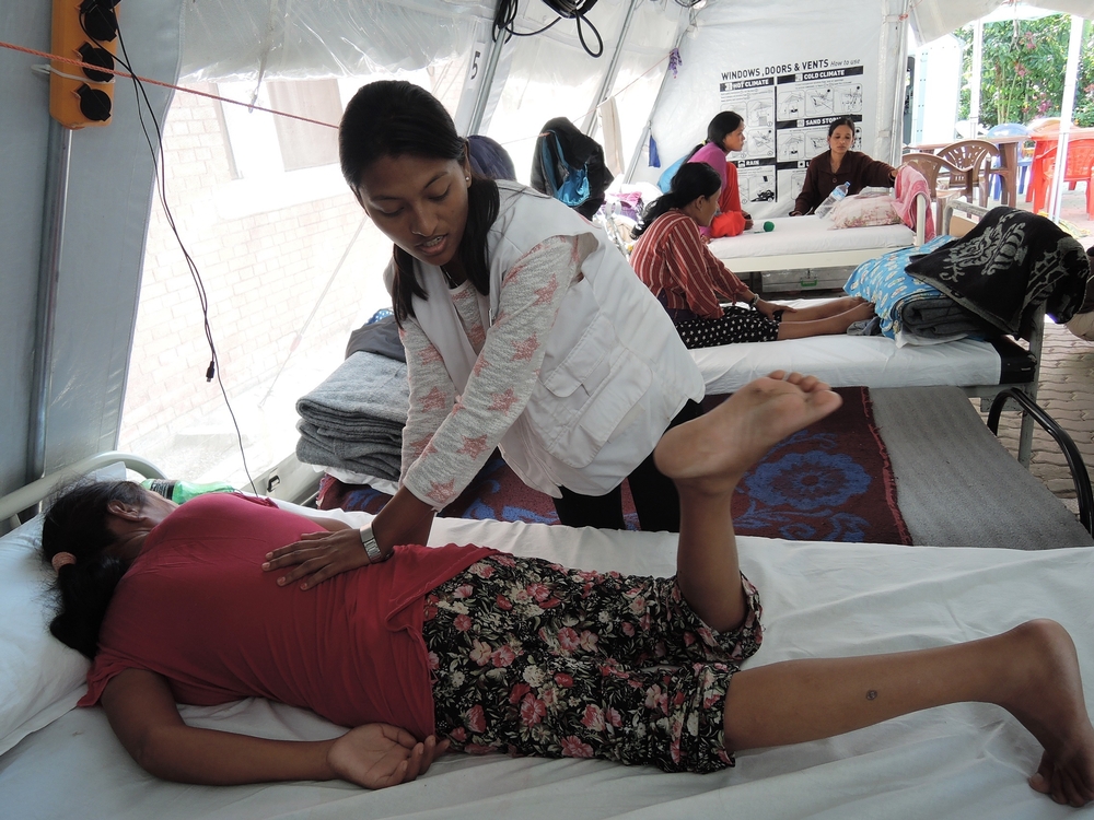 Een medewerker van AZG leert een patiënt in het Spinal Injury Rehabilitation Centre enkele oefeningen aan. ©AZG 