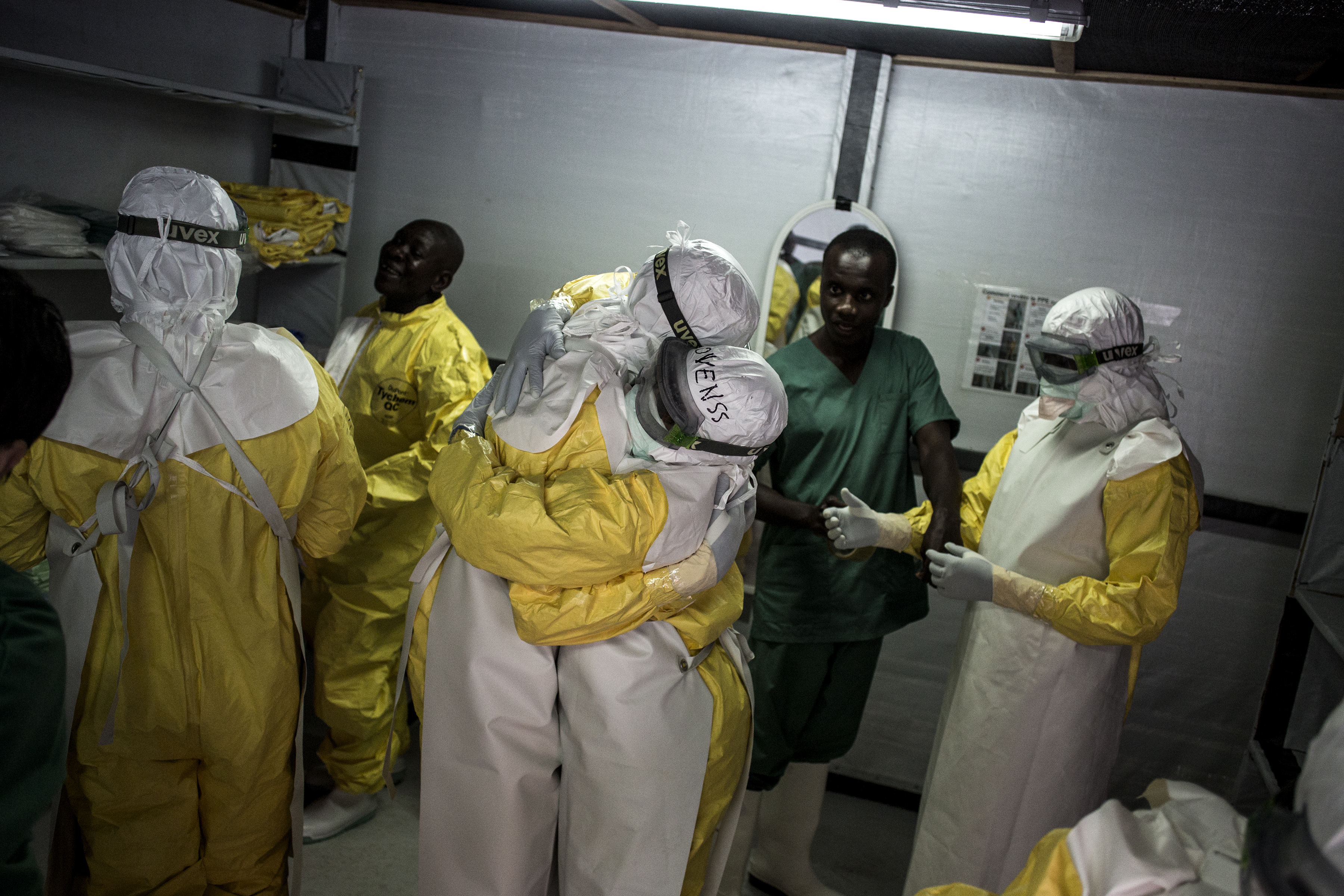 Les travailleurs de la santé dans leur équipement de protection personnel se prennent dans les bras avant de se rendre dans la zone rouge du centre de traitement Ebola géré par MSF à Bunia. C’est la 10e épidémie d'Ebola en RDC. Avec plus de 300 cas confirmés et près de 200 morts, elle est devenue la plus grave jamais connue par le pays. © John Wessels, 7 novembre 2018