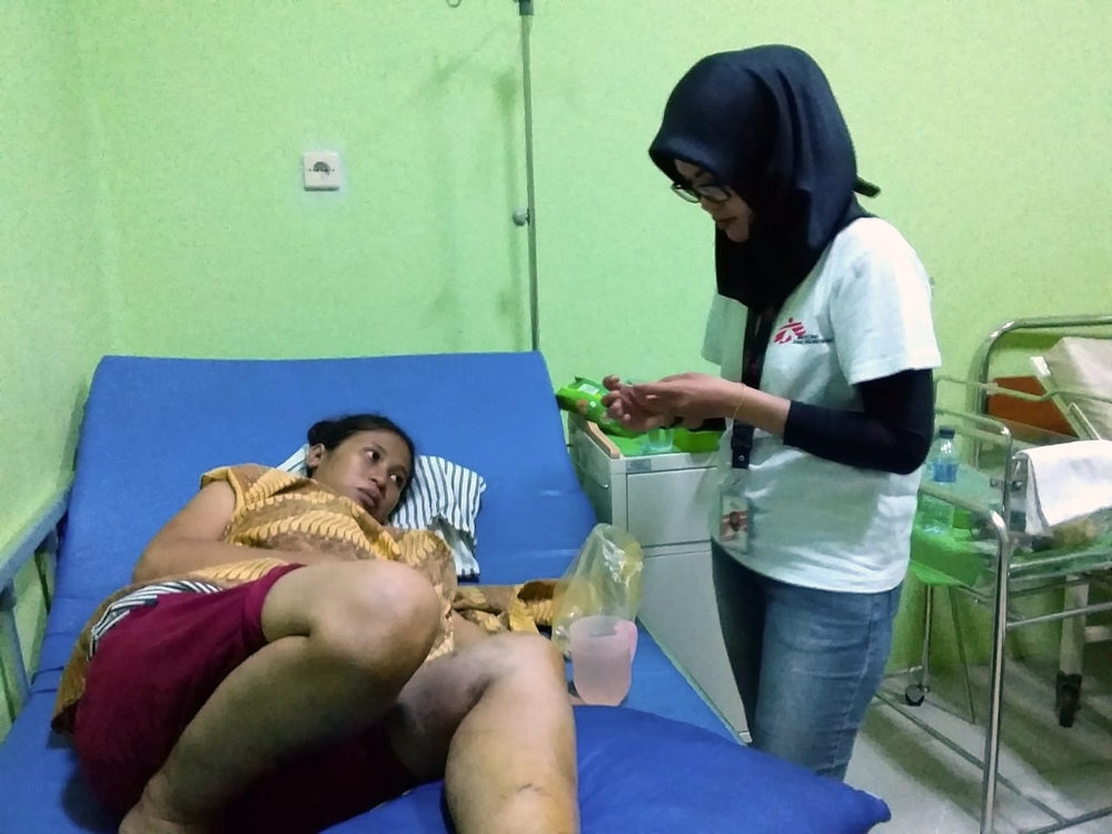 Vroedvrouw Dina Afriyanti controleert de vitale functies van een patiënt, die werd geraakt door vallend puin, in het gezondheidscentrum van Labuan. © Jedeth Mamora. Java, 23 december.