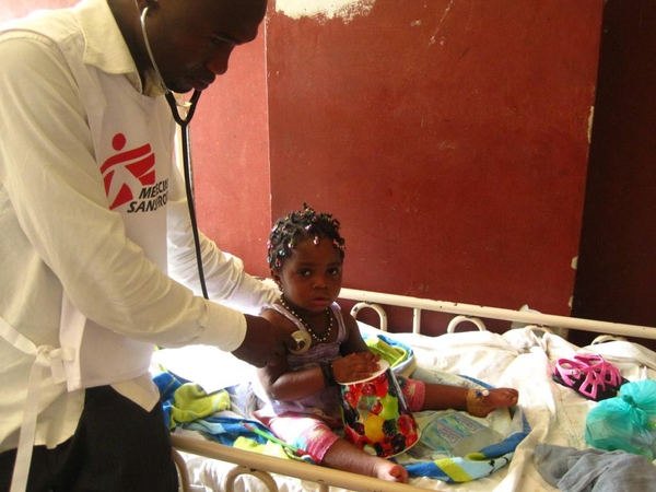 Kamory Kaeita, médecin MSF, examine une petite fille atteinte de complications respiratoires dues à la rougeole © Lirios Pasto Galiano