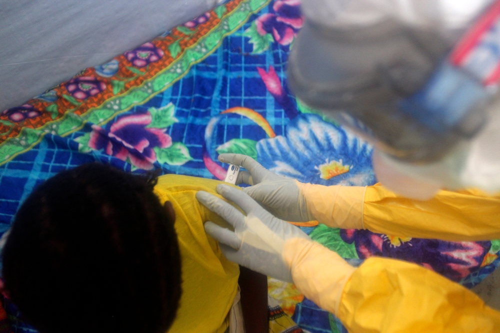 Een verpleger neemt de temperatuur. Koorts is een teken van ebola © Amandine Colin