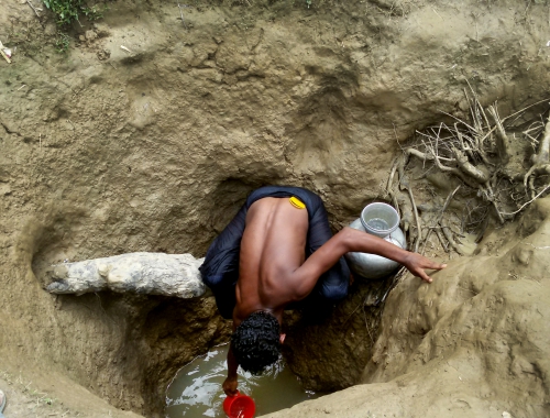 Un homme récupère l'eau d'un puits creusé à la main dans un camp de fortune d'Unchiparang. Même dans un puits de 3m de profondeur, l'eau n'est pas nécessairement potable. MSF reconstruit certains de ces puits pour les rendre plus propres et plus sûrs, et traite l'eau pour s'assurer qu'elle soit potable. © Paul Andrew Jabor/MSF